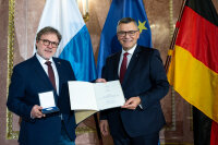 Staatsminister Dr. Florian Herrmann überreicht Roman Beer die Medaille für Verdienste um die Zivil-Militärische Zusammenarbeit